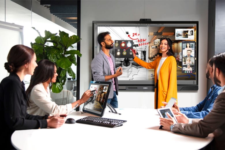 Diverse business team engaged in a collaborative session using a SMART interactive display.