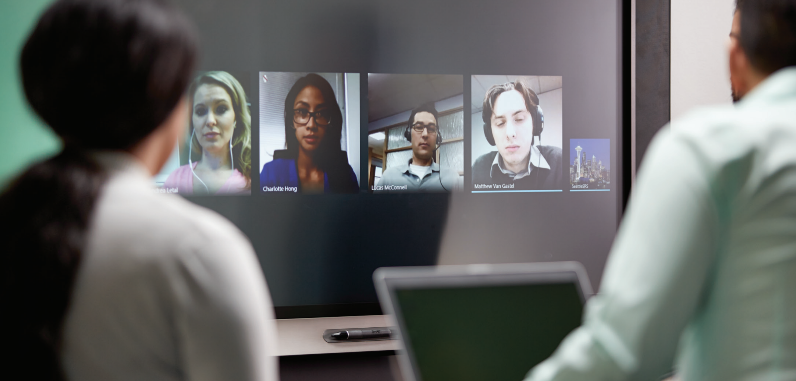 Employees connecting with coworkers through video chat using a SMART Board for Business.